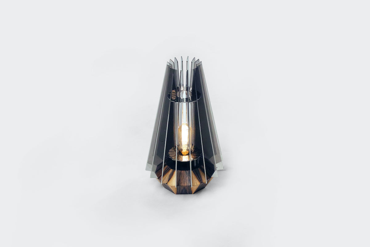 Détail inimitable d’une atmosphère raffinée, cette lampe abrite en son cœur géométrique une source lumineuse qui fait naître une intimité feutrée. Astrolux est composée d’une couronne de 16 ailettes métalliques qui partitionnent la lumière pour en diffuser un rayonnement indirect et multidirectionnel.&nbsp;