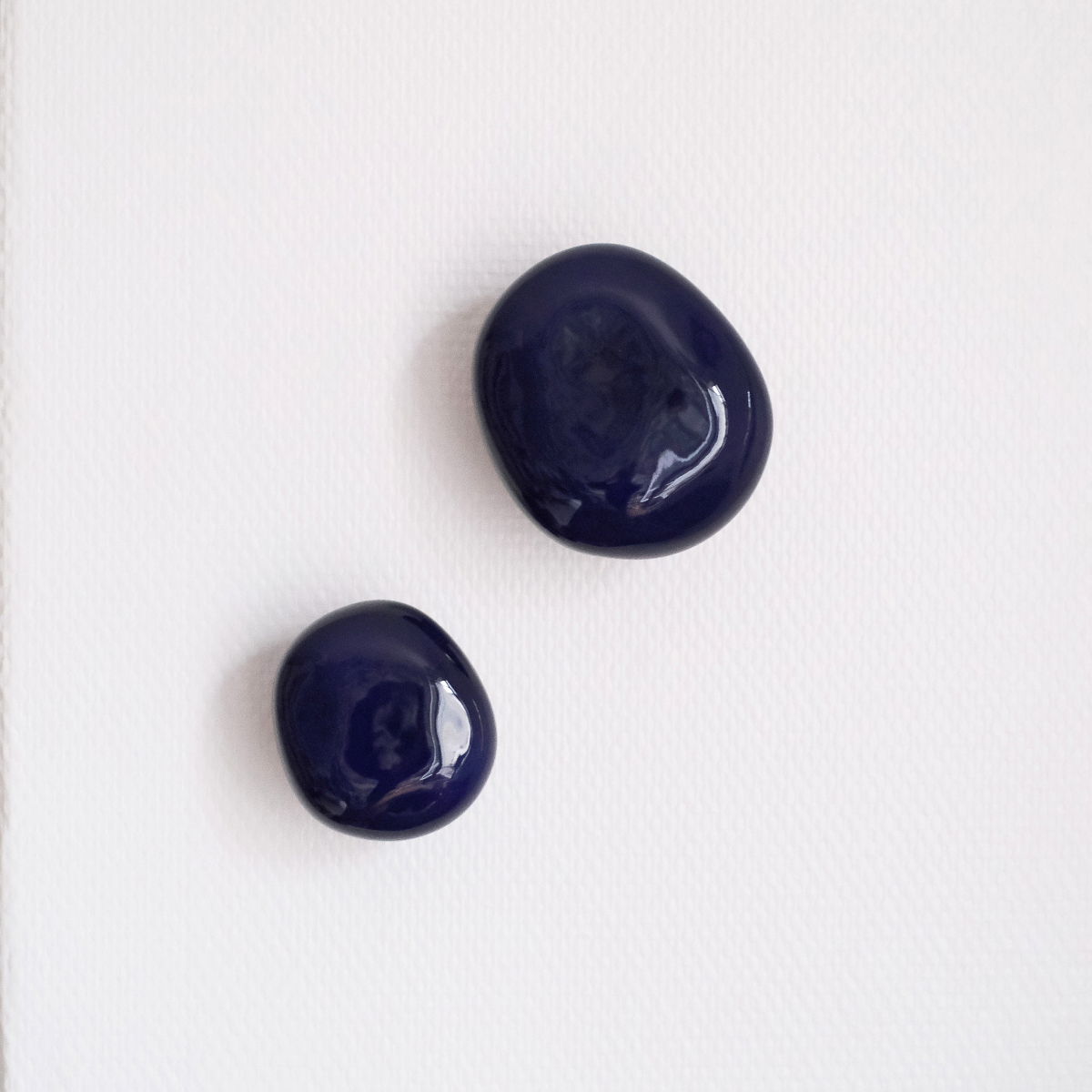 La patère Agate tire son nom de la pierre précieuse éponyme. Les Grecs et les Égyptiens l'utilisaient déjà dans la confection d'objets sacrés. Chaque patère possède sa propre personnalité, accentuée par les émaux cristallisés ou colorés qui s'harmonisent avec sa forme douce et organique, reflétant la diversité des teintes présentes dans les pierres d'Agate.

Son design intemporel et organique évoque la beauté et la simplicité des galets, tandis que sa délicate base est ornée d'une bague en laiton brossé