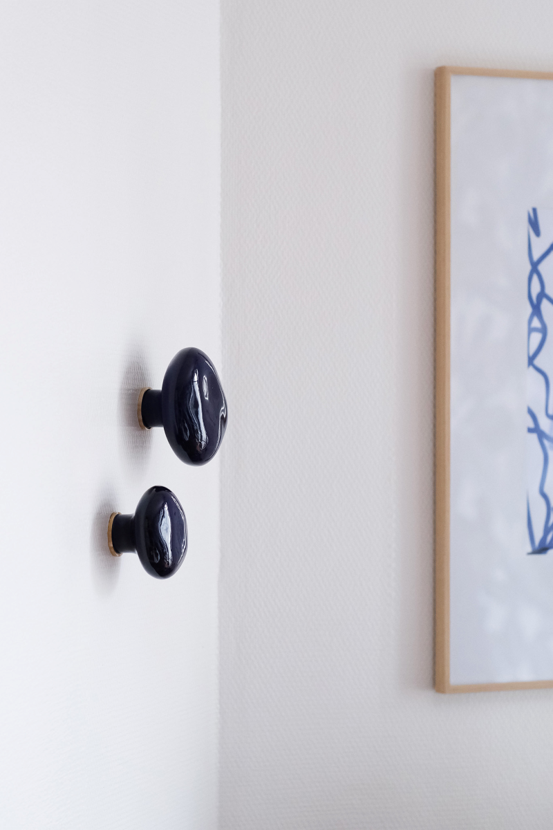 La patère Agate tire son nom de la pierre précieuse éponyme. Les Grecs et les Égyptiens l'utilisaient déjà dans la confection d'objets sacrés. Chaque patère possède sa propre personnalité, accentuée par les émaux cristallisés ou colorés qui s'harmonisent avec sa forme douce et organique, reflétant la diversité des teintes présentes dans les pierres d'Agate.

Son design intemporel et organique évoque la beauté et la simplicité des galets, tandis que sa délicate base est ornée d'une bague en laiton brossé