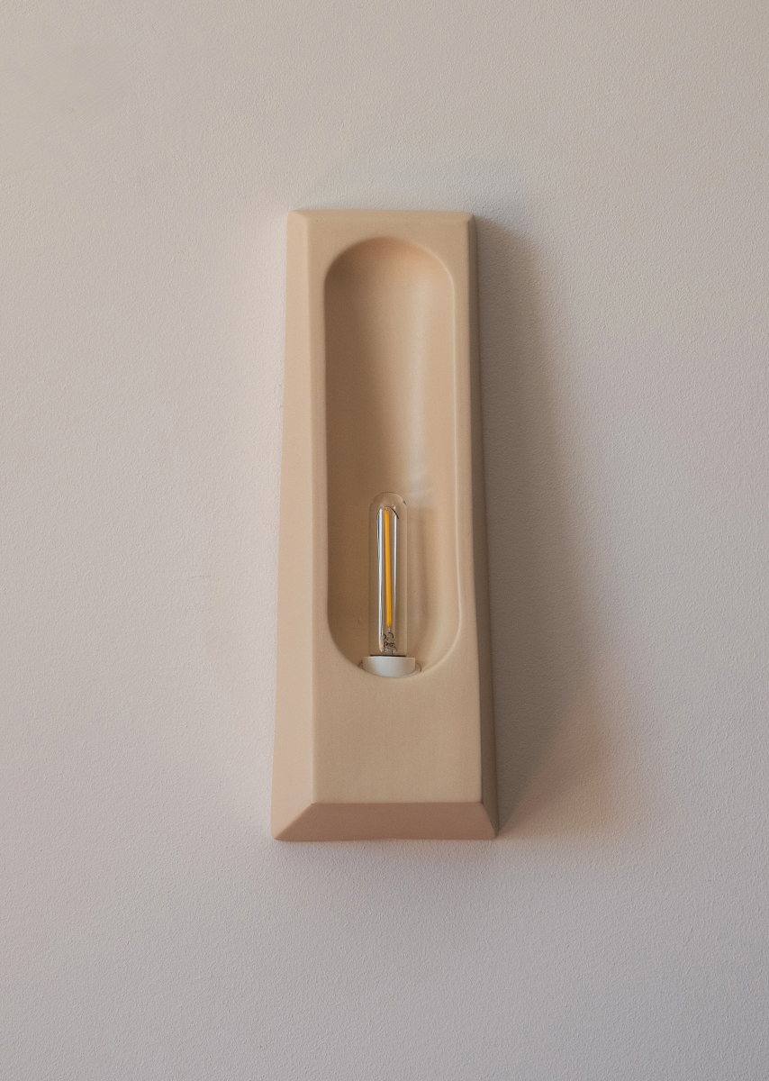 Wall sconce Alcove by Violaine d'Harcourt, in glazed ceramic hand-formed in Portugal. An enveloping silhouette inspired by the architectural alcove, diffusing softened, intimate light.