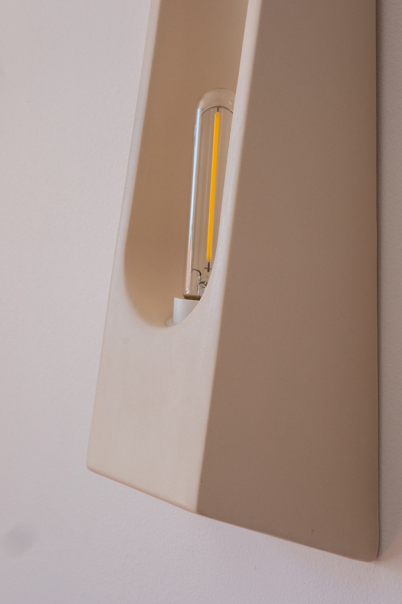 Wall sconce Alcove by Violaine d'Harcourt, in glazed ceramic hand-formed in Portugal. An enveloping silhouette inspired by the architectural alcove, diffusing softened, intimate light.