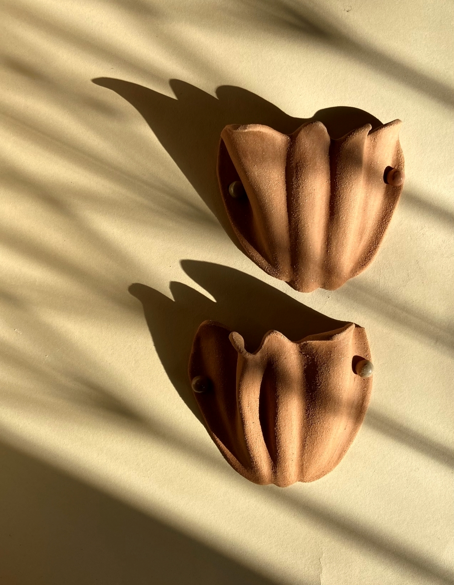 Wall sconce Florale by Thalia Dalecky, in chamotte beige-orange stoneware, hand-modeled and unglazed. Inspired by flora, a tulip opening to the light, raw and softly mineral.