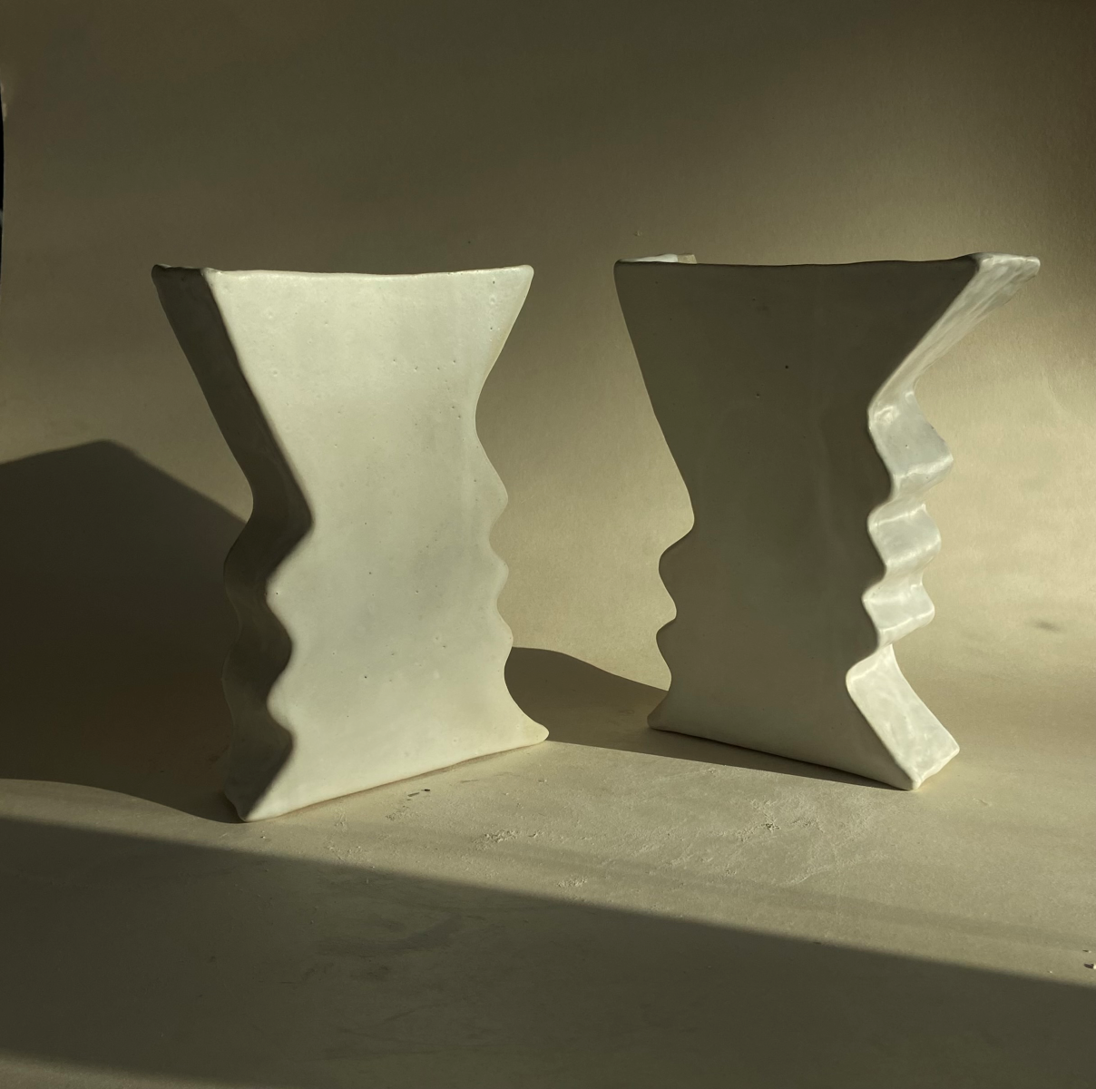 Créée à partir de grès crème émaillé en blanc mat avec une barre en céramique intégrée à l'arrière pour l'accrochage mural, la paire d'appliques Totems est à la fois décorative et lumineuse. L'artiste Thalia Dalecky propose un design géométrique et minimaliste, représentant des lignes des visages de profil. 