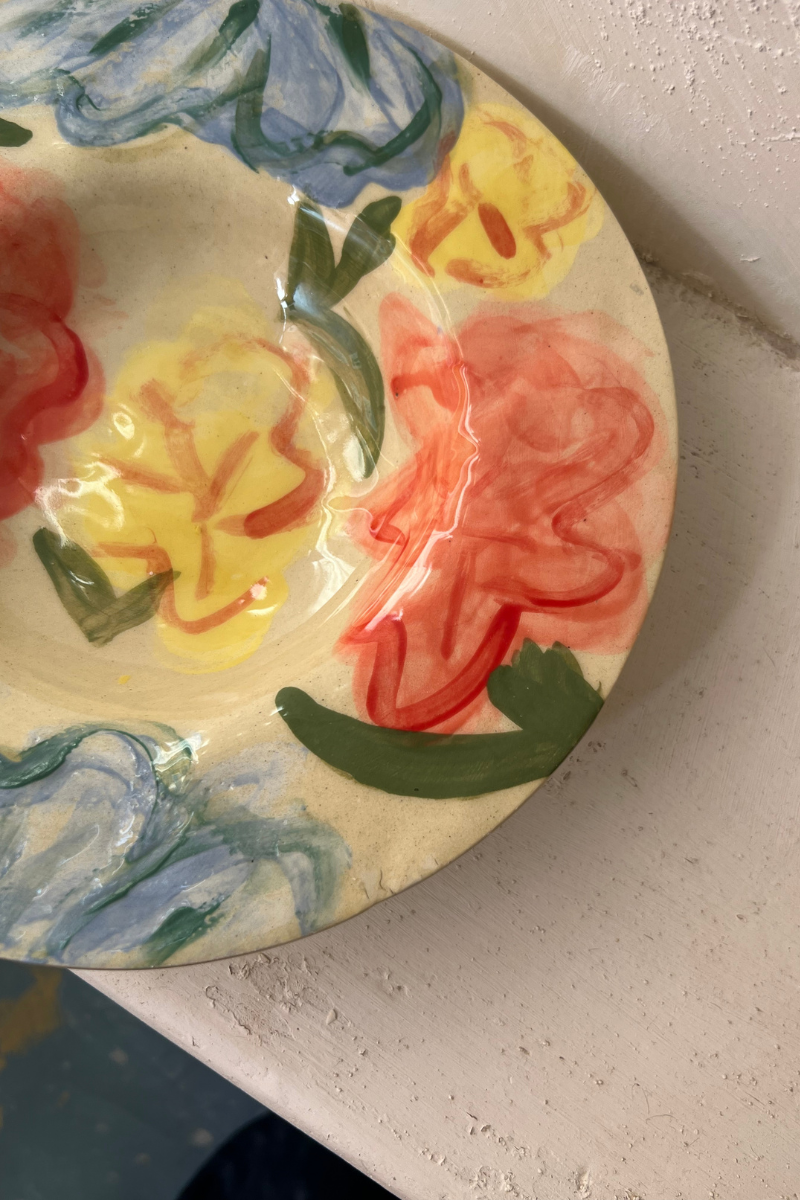 Ces assiettes Florales naissent au tour de potier, puis prennent vie sous les pinceaux de l’atelier marseillais de L’Irrégulière Céramique. Sur chaque pièce, un jardin spontané se déploie : fleurs abstraites, pétales vibrants, couleurs qui s’entremêlent et jouent avec la matière brute.