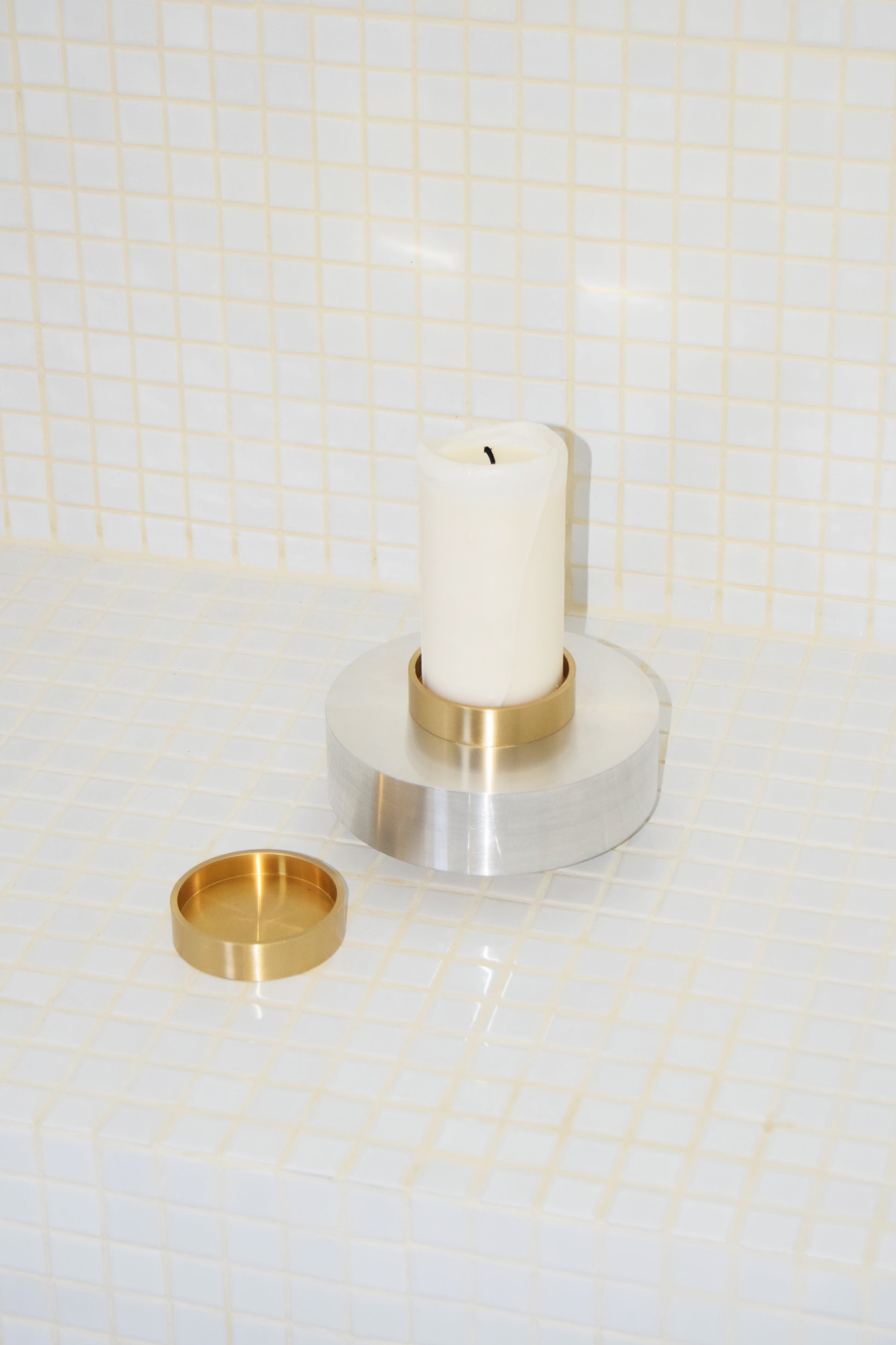 Contraste entre les métaux bruts et la fluidité de la cire, les bougeoirs sont apparus tout de suite dans le design de Marine Breynaert, et sont devenus iconiques depuis. Ce sont toujours des pièces à assembler : chaque bougeoir est une architecture minimale. Ils peuvent être posés seuls sur une cheminée, en famille en centre de table, ou mélangés à des bougeoirs anciens. Leur style intemporel se marie à des intérieurs très contemporains comme aux genres classiques et art déco.