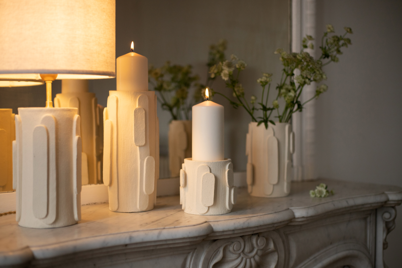 Le bougeoir Glow en exclusivité chez Caroline Andréoni La Maison tire son nom de l'éclat qu'il apporte, en anglais, évoquant ainsi la luminosité naturelle qui inspire infatigablement la créatrice Adeline Delesalle. Ce vase en grand modèle est réalisé selon la technique de la plaque, résultat du savoir-faire de l'artiste, entièrement réalisé à la main dans ses ateliers en France. Les cylindres sont "griffés" afin de créer un contraste de matière entre le support et les éléments ajoutés.