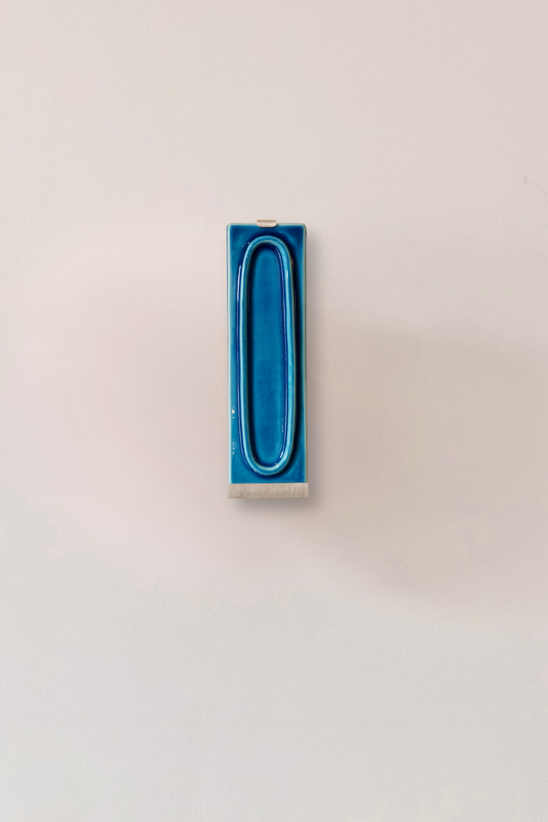 Zoom sur l'applique arty bleu.. L’applique Arty, imaginée par Coline Leleu et Sébastien Carette, porte bien son nom : elle apporte une touche artistique discrète qui habille le mur avec légèreté. Chaque carreau de céramique est façonné à la main au Portugal, et révèle ses nuances et textures uniques, témoignant du geste de l’artisan.