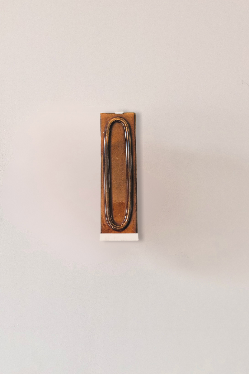 Zoom sur l'applique arty porto. L’applique Arty, imaginée par Coline Leleu et Sébastien Carette, porte bien son nom : elle apporte une touche artistique discrète qui habille le mur avec légèreté. Chaque carreau de céramique est façonné à la main au Portugal, et révèle ses nuances et textures uniques, témoignant du geste de l’artisan.