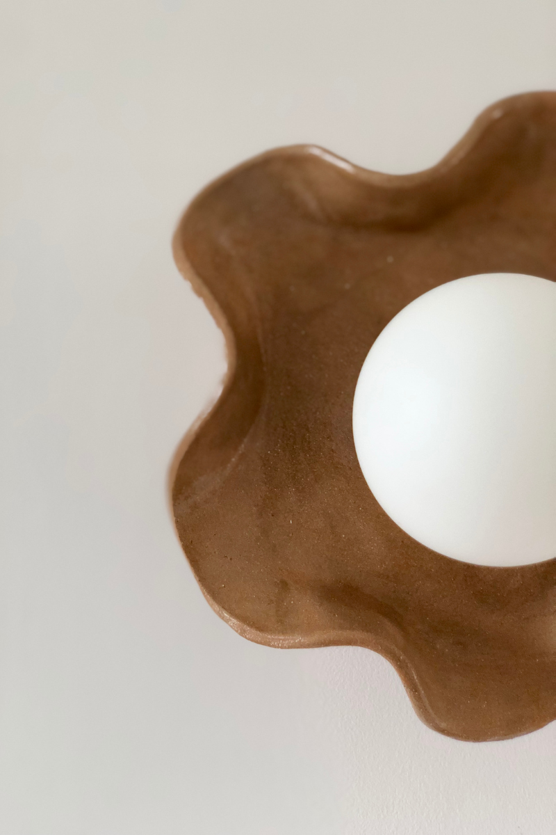 Ici un zoom sur l'applique émail chocolat. L’applique Jelly, s’inspire du monde marin. Ses lignes ondulées rappellent le mouvement de l’eau et la légèreté des méduses, apportant à l’espace une touche à la fois vivante et apaisante. 