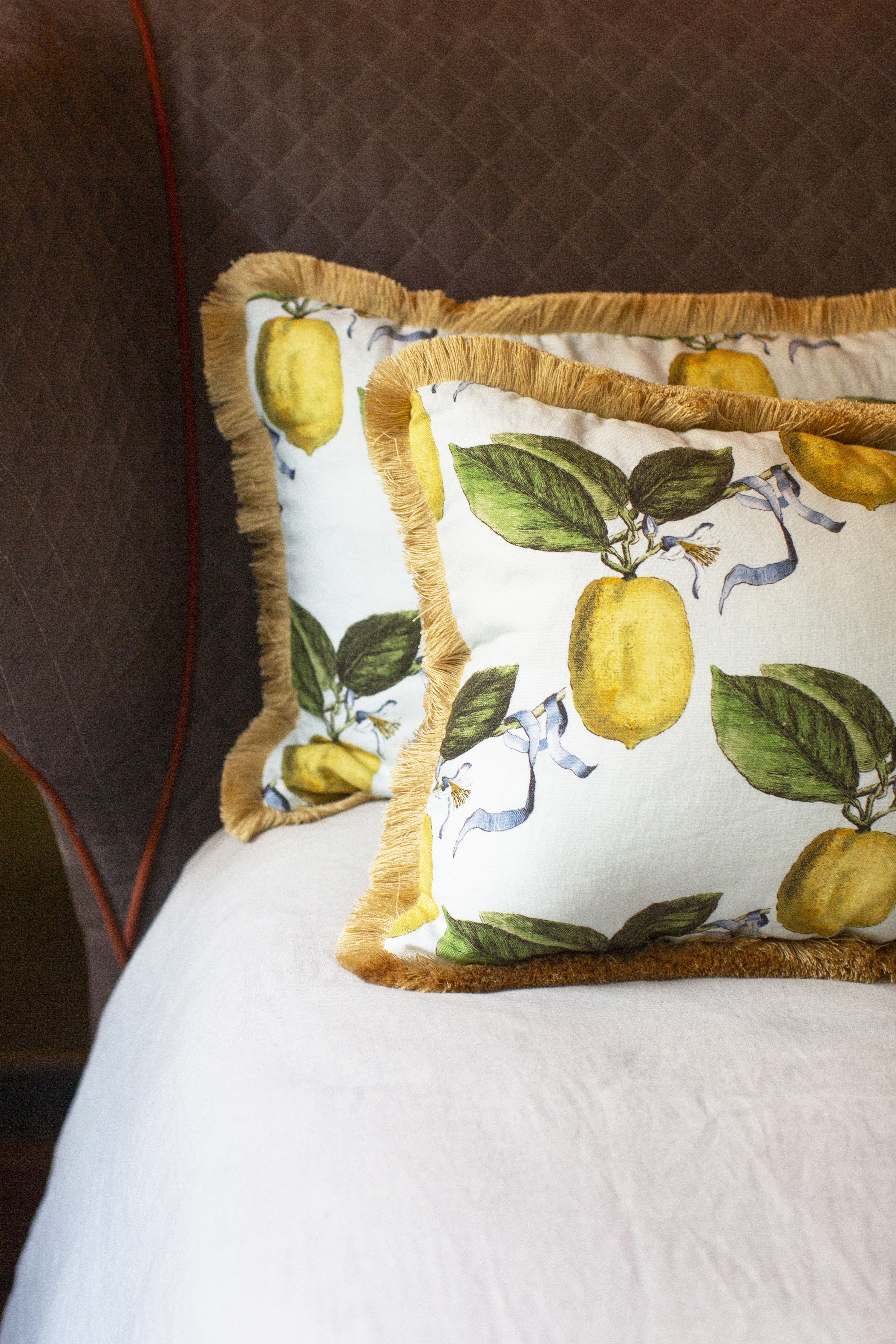 Ce coussin s’impose comme une pièce de caractère au sein de la collection Caroline Andreoni La Maison. Son imprimé citrus, à la fois lumineux et vitaminé, évoque la douceur d’un jardin méditerranéen et insuffle instantanément énergie et vitalité à votre intérieur. Le passepoil doré, discret mais élégant, souligne les contours du coussin avec finesse et capte la lumière pour un effet subtilement précieux.