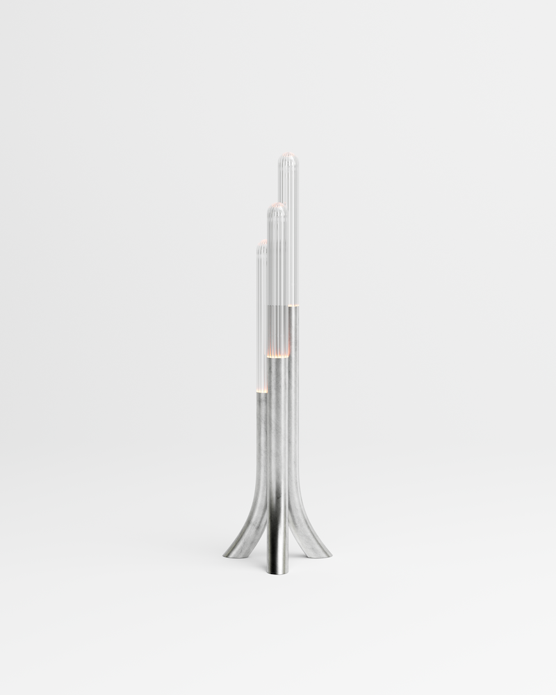 La rencontre de Mickaël avec un artisan verrier lui permet de retranscrire toutes les nuances d'oscillations et de reflets auxquels le paysage méditerranéen l'a habitué. Des cannes striées, fumées ou transparentes assemblées sous la forme d'un cactus élancé et raffiné, qui révèlent toute leur singularité en s'éclairant.  Tous les reliefs du verre sont projetés sur l'environnement qui l'entoure. Une ode au territoire d'origine de Mickaël.