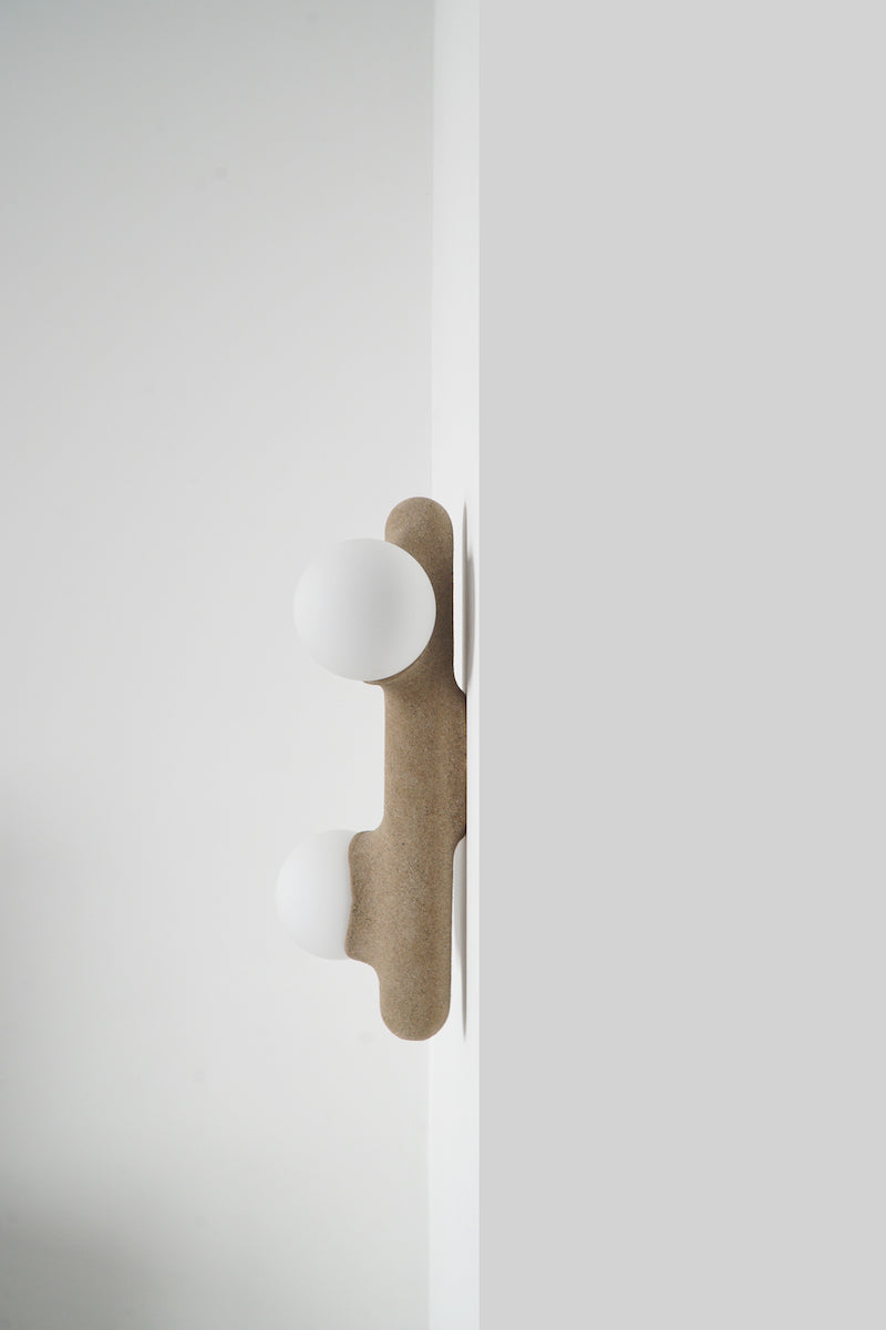 Intrigué par le figuier de barbarie qui se révèle être un outil naturel luttant contre l'érosion des sols, et participant à la préservation du territoire, Mickaël s'en inspire pour dessiner cette lampe. Volupté et douceur, sont les maîtres mots pour célébrer cette plante.  Modelée à partir de la terre que le figuier protège, l'applique Figue de Barbarie naît en terre cuite par la main du designer. Les opalines comme des baies charnues rayonnent, et mettent en lumière cette prouesse naturelle.