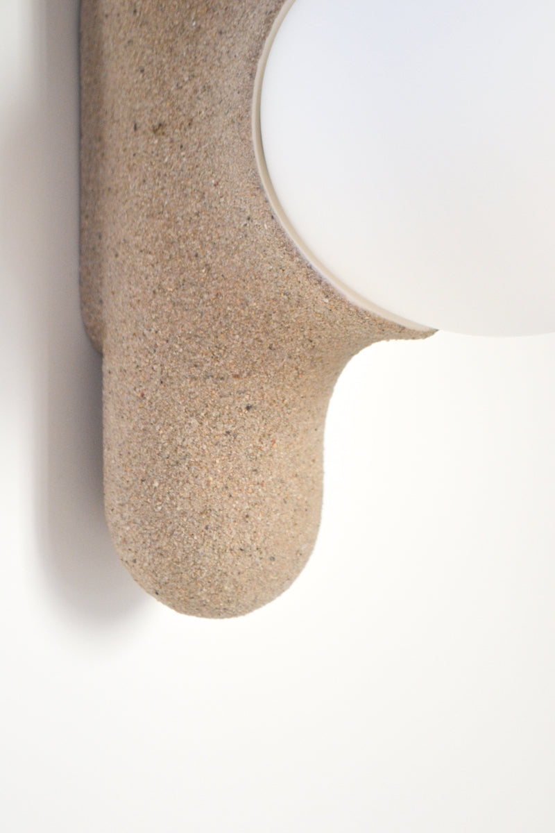 Intrigué par le figuier de barbarie qui se révèle être un outil naturel luttant contre l'érosion des sols, et participant à la préservation du territoire, Mickaël s'en inspire pour dessiner cette lampe. Volupté et douceur, sont les maîtres mots pour célébrer cette plante.  Modelée à partir de la terre que le figuier protège, l'applique Figue de Barbarie naît en terre cuite par la main du designer. Les opalines comme des baies charnues rayonnent, et mettent en lumière cette prouesse naturelle.