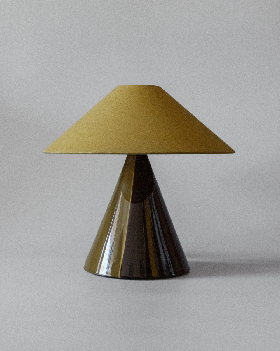 Basé dans le sud de la France, le duo mère-fille à l'origine de Mattina Moderna apporte leurs racines italiennes à la lampe à poser Caterina.

Dotée d'un design bicolore peint à la main et d'un abat-jour tonkinois en tissu de coton, cette lampe de table élégante et minimaliste résulte en une combinaison totalement unique de couleurs et de textures, rendant chaque pièce unique en son genre.&nbsp;

Ici en coloris Golden Olive et pied vert et marron.