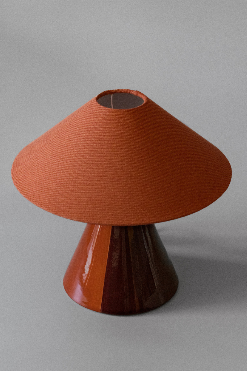 Basé dans le sud de la France, le duo mère-fille à l'origine de Mattina Moderna apporte leurs racines italiennes à la lampe à poser Caterina.

Dotée d'un design bicolore peint à la main et d'un abat-jour tonkinois en tissu de coton, cette lampe de table élégante et minimaliste résulte en une combinaison totalement unique de couleurs et de textures, rendant chaque pièce unique en son genre.