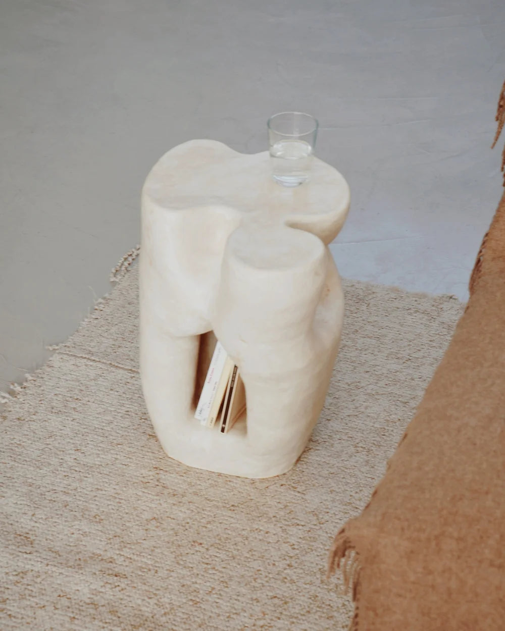 Table d’appoint aux courbes uniques, réalisée à la main par Marguerite Porche dans son atelier, à Lyon. Cette table possède une petite niche en son coeur pour y déposer quelques livres. Fabriquée en grès blanc et enveloppée dans un émail blanc soyeux. D’autres formes, formats et teintes sur demande.