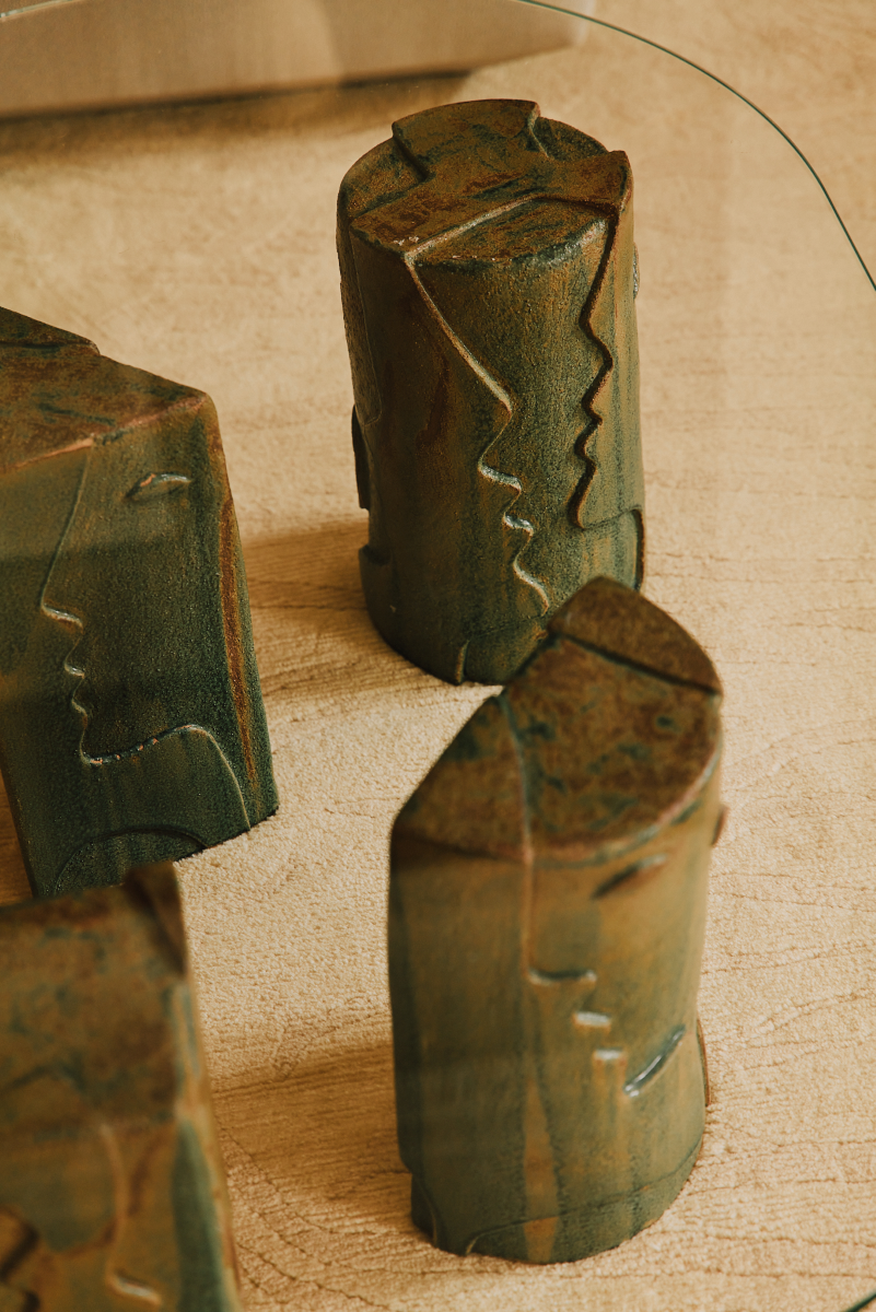 Confectionnée par Thalia Dalecky, artiste céramiste, la table basse Fiesta propose quatre pieds en grès sable sculptés représentant des visages en bas relief, émaillés de couleur vert/brun. Les pieds ne comprennent pas le plateau de verre. Un devis peut être réalisé pour en fabriquer une sur mesure : rond, carré, ovale, oblong, rectangle, demi-cercle pouvant aller jusqu'à 2 centimètres d'épaisseur. Cette demande est à ajouter aux prix des pieds de la table.