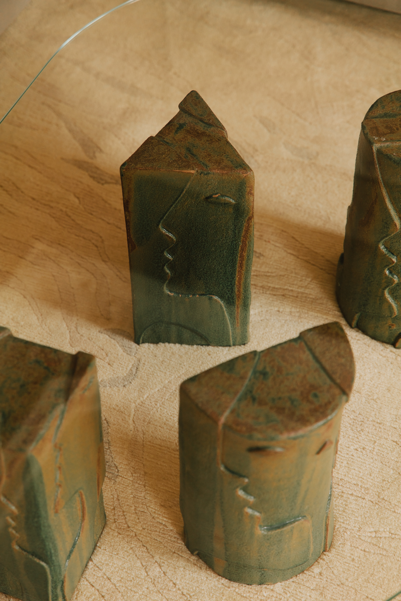 Confectionnée par Thalia Dalecky, artiste céramiste, la table basse Fiesta propose quatre pieds en grès sable sculptés représentant des visages en bas relief, émaillés de couleur vert/brun. Les pieds ne comprennent pas le plateau de verre. Un devis peut être réalisé pour en fabriquer une sur mesure : rond, carré, ovale, oblong, rectangle, demi-cercle pouvant aller jusqu'à 2 centimètres d'épaisseur. Cette demande est à ajouter aux prix des pieds de la table.