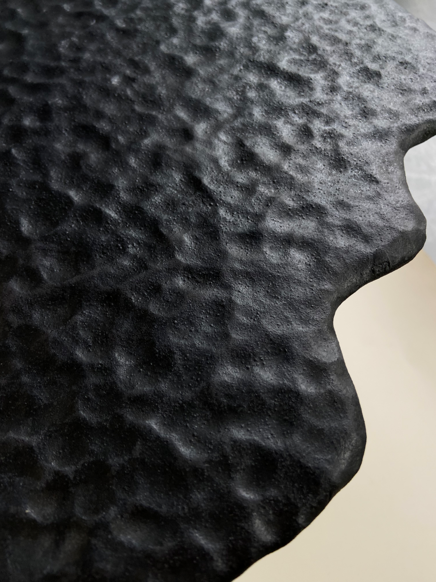 La petite table Ondulée Noire fait partie de la collection "Ondulations", une série d'œuvres et de pièces design tournant autour de la notion des vagues, du mouvement organique de l'eau, de ses formes enveloppantes et rassurantes aux textures diverses invitant au toucher. En exclusivité chez Caroline Andréoni La Maison, ce guéridon confectionné par l'artiste Thalia Dalecky va de paire avec la petite table ondulée nacré de la même collection.