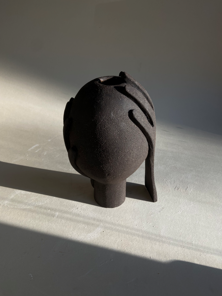 Vase Je te protège by Thalia Dalecky, in raw black stoneware from the « À mains nues » collection. The enveloping form carries the gesture of protection, ceramic as sheltering skin.