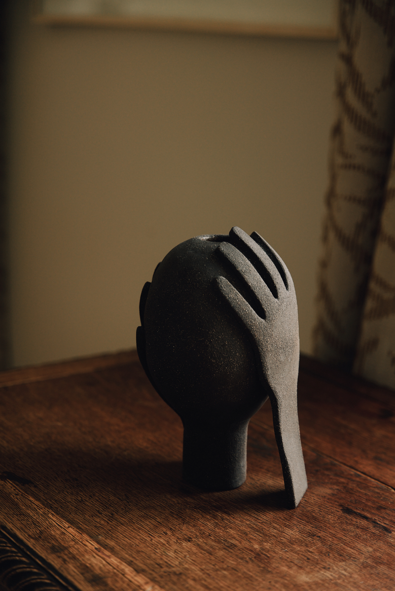 Vase Je te protège by Thalia Dalecky, in raw black stoneware from the « À mains nues » collection. The enveloping form carries the gesture of protection, ceramic as sheltering skin.