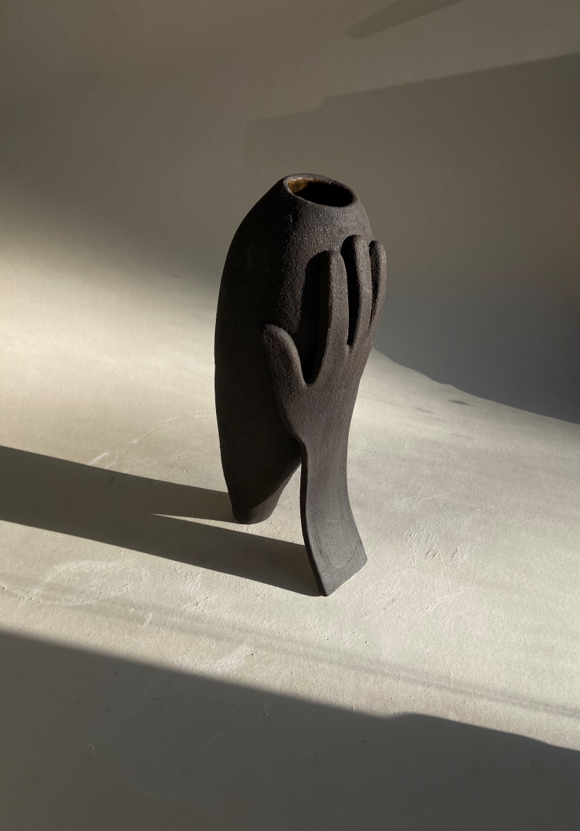 Vase Je te soutiens by Thalia Dalecky, in raw black stoneware from the « À mains nues » collection. The slender vertical silhouette speaks of standing beside the other, support, consolation, direct ceramic gesture.