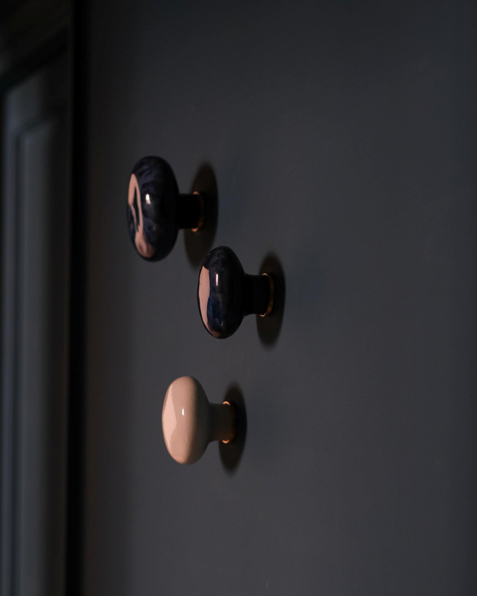 La patère Agate tire son nom de la pierre précieuse éponyme. Les Grecs et les Égyptiens l'utilisaient déjà dans la confection d'objets sacrés. Chaque patère possède sa propre personnalité, accentuée par les émaux cristallisés ou colorés qui s'harmonisent avec sa forme douce et organique, reflétant la diversité des teintes présentes dans les pierres d'Agate.

Son design intemporel et organique évoque la beauté et la simplicité des galets, tandis que sa délicate base est ornée d'une bague en laiton brossé