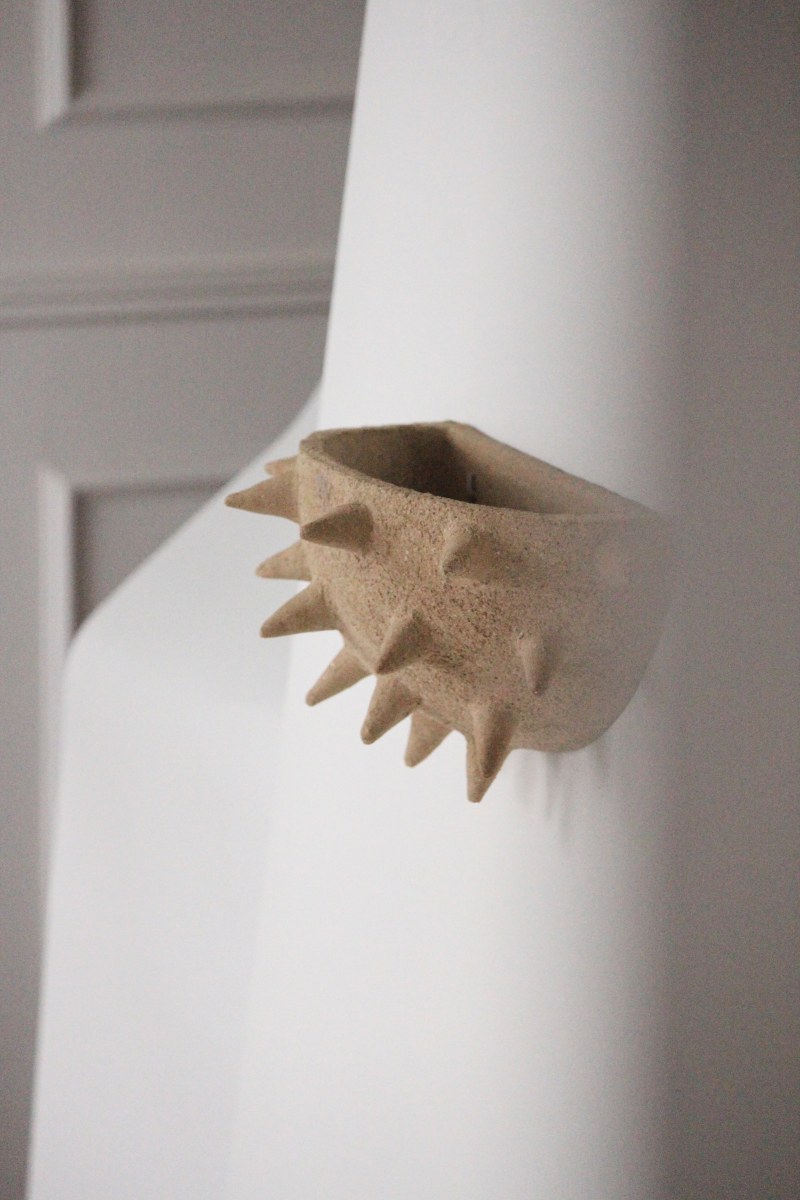 Cette applique Jupiter constituée de grès chamotte présente une texture avec des grains de sable. Chaque pièce est unique, numérotée, signée et modelée manuellement dans un grès chamotte, une argile cuite plusieurs fois entre 900 et 1400 degrés. Au cours de ce processus, l'objet devient aussi solide que la pierre. C'est par l'assemblage, le modelage, la sculpture et les différentes cuissons que l'objet se révèle.

Grâce à la céramique, Alan Louis capture l’essence de l’élégance brute et naturelle.