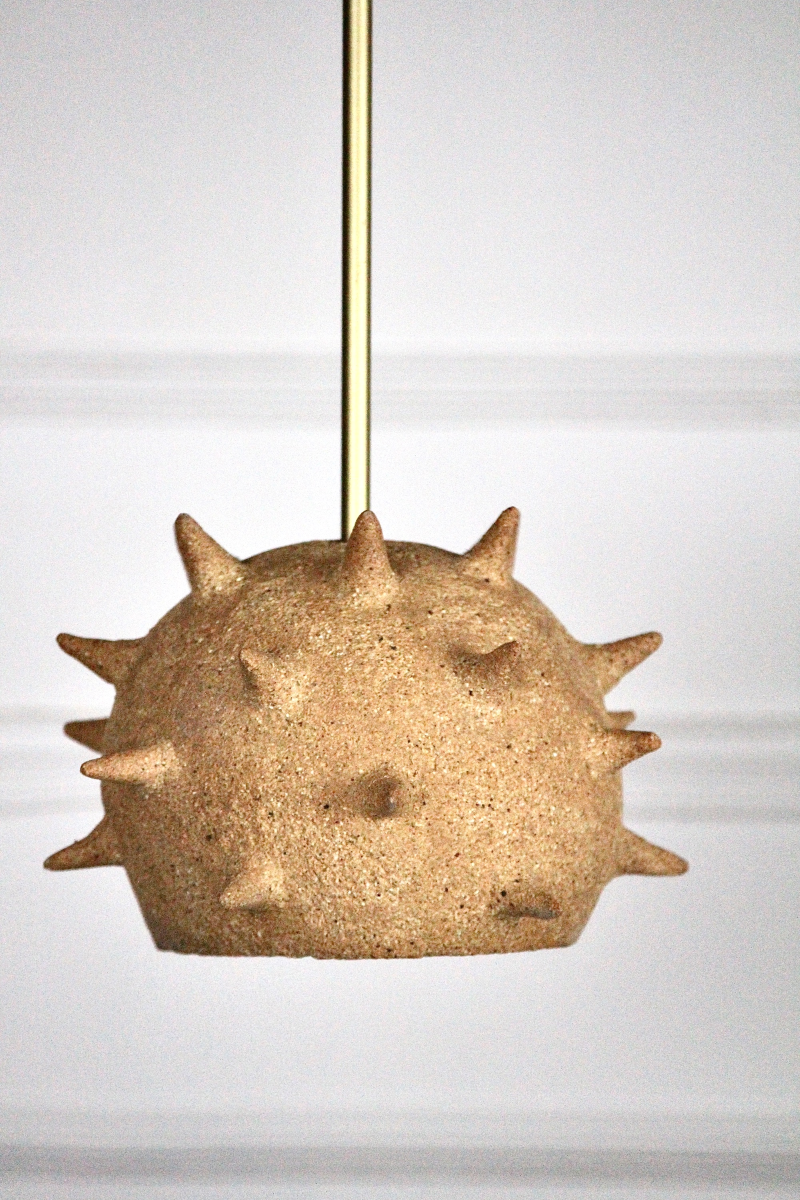 Cette suspension Jupiter constituée de grès chamotte présente une texture avec des grains de sable. La tige et le pavillon sont faits de laiton brossé. Chaque pièce est unique, numérotée, signée et modelée manuellement dans un grès chamotte, une argile cuite plusieurs fois entre 900 et 1400 degrés.

Grâce à la céramique, Alan Louis capture l’essence particulière de l’élégance brute et naturelle.