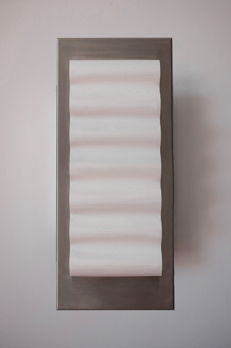 Les appliques Frame Alu Brut de Violaine d'Harcourt sont fabriquées à la main au Portugal, en aluminium et papier.

Dotées d'un design minimaliste et rendant un subtil hommage à l'architecture moderne, les appliques murales Frame sont réalisées avec des matériaux contrastés qui rehaussent le toucher doux d'une vague de papier.