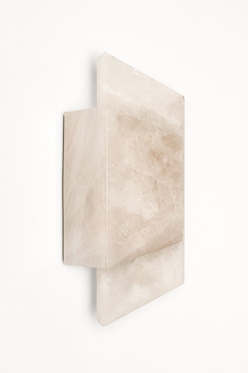 Applique Enveloppée en golden quartzite et laiton est Inspirée de l’art du pliage et des formes enveloppantes de l’origami japonais. Enveloppée joue sur un équilibre délicat entre puissance minérale et apparente légèreté. La pierre, traversée par la lumière, évoque la finesse des papiers de soie et de riz utilisés dans les lanternes asiatiques traditionnelles.