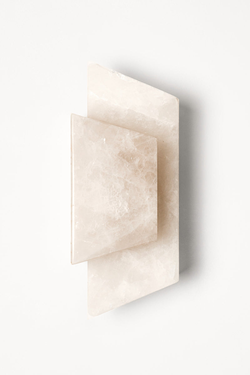 Applique Enveloppée en golden quartzite et laiton est Inspirée de l’art du pliage et des formes enveloppantes de l’origami japonais. Enveloppée joue sur un équilibre délicat entre puissance minérale et apparente légèreté. La pierre, traversée par la lumière, évoque la finesse des papiers de soie et de riz utilisés dans les lanternes asiatiques traditionnelles.