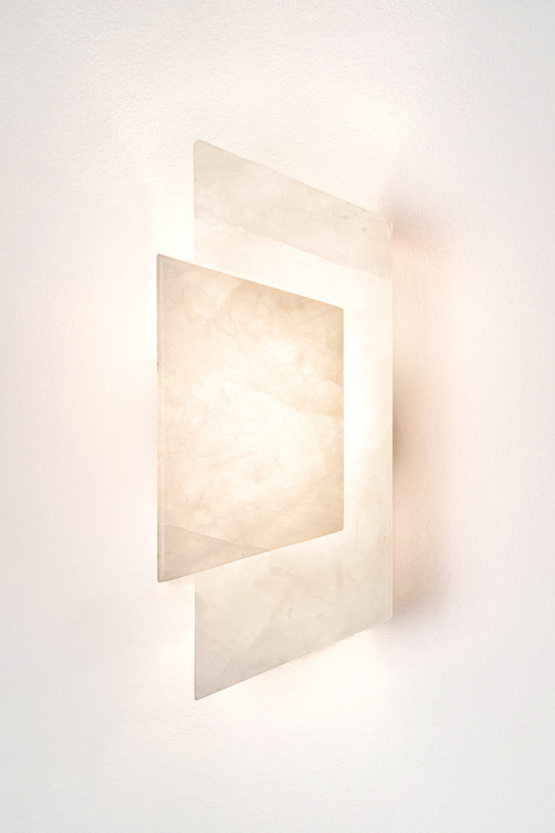 Applique Enveloppée en golden quartzite et laiton est Inspirée de l’art du pliage et des formes enveloppantes de l’origami japonais. Enveloppée joue sur un équilibre délicat entre puissance minérale et apparente légèreté. La pierre, traversée par la lumière, évoque la finesse des papiers de soie et de riz utilisés dans les lanternes asiatiques traditionnelles.