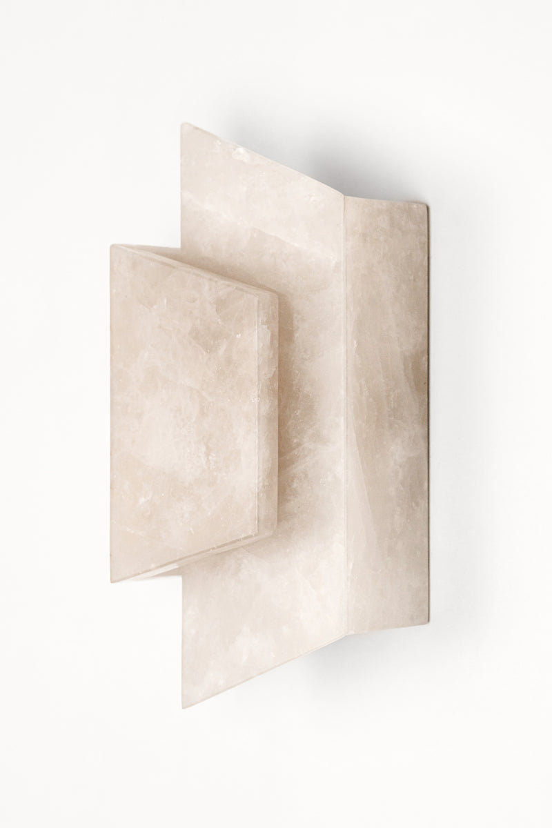 Applique Enveloppée en golden quartzite et laiton est Inspirée de l’art du pliage et des formes enveloppantes de l’origami japonais. Enveloppée joue sur un équilibre délicat entre puissance minérale et apparente légèreté. La pierre, traversée par la lumière, évoque la finesse des papiers de soie et de riz utilisés dans les lanternes asiatiques traditionnelles.