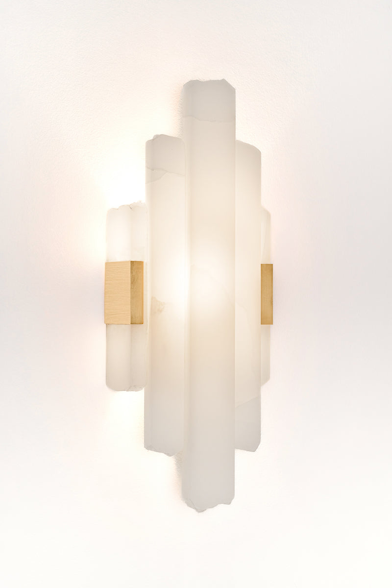 Applique Cascade, en onyx pure white structure Laiton s'inspire des&nbsp;blocs de marbres extraits des carrières. Mélange subtile de formes brutes, organiques, minérales et de découpes franche aux lignes droites
