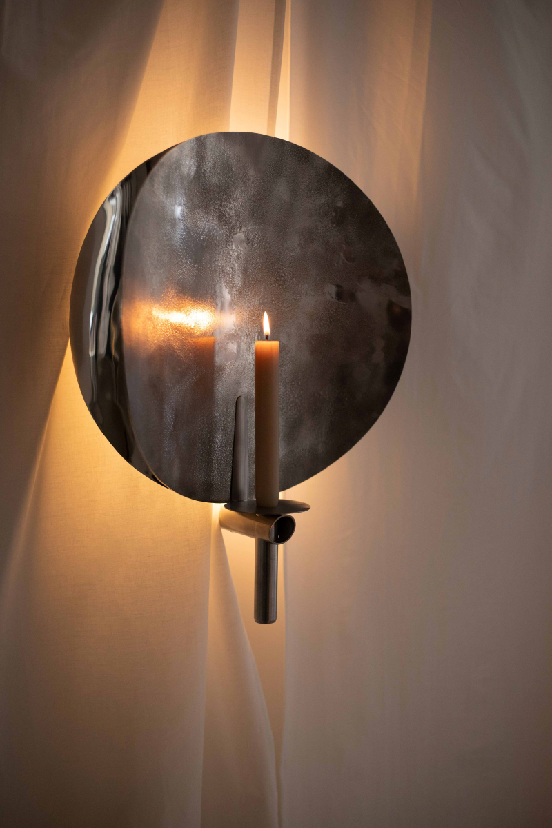 L'applique murale Sigri joue avec deux temporalités : l’ancienne, avec la flamme d’une bougie, et l’actuelle, avec la douceur d’un éclairage LED. Lumière indirecte et apaisante lorsqu’elle est électrique, elle se transforme en une présence intime et vibrante dès que la bougie prend le relais.

Selon l’envie ou le moment de la journée, elle accompagne vos instants de contemplation et habille votre intérieur d’une atmosphère singulière.