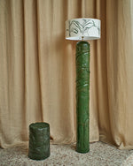 Floor lamp Guyane by Thalia Dalecky, in chamotte orange stoneware with a green glaze, coil-built. High-relief carvings of foliage and bodies, the tropical jungle held in clay and light.
