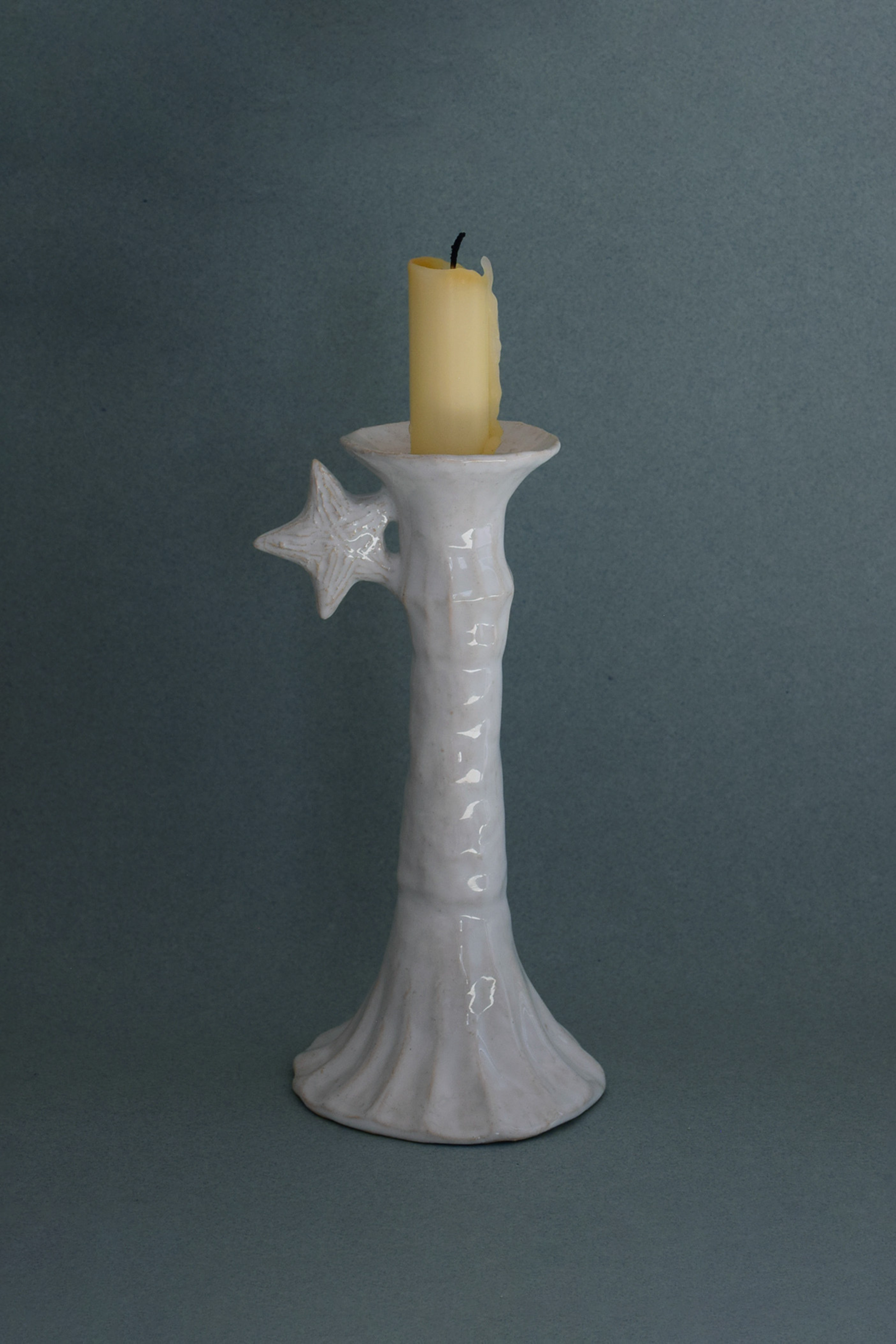 Le Grand Chandelier, issu de la collection Pierrot, évoque l’univers tendre et mélancolique du célèbre clown rêveur. Son modelage, tout en douceur, rend hommage à la nuit et à ses étoiles en s'inspirant de la célèbre comptine Au Clair de la Lune. Qu’il éclaire une table de chevet ou un coin de salon, Le Grand Chandelier incarne une poésie discrète. Façonné entièrement à la main, chaque bougeoir présente des irrégularités subtiles qui témoignent d'un geste instinctif.

Pièce unique, fabriquée à la main