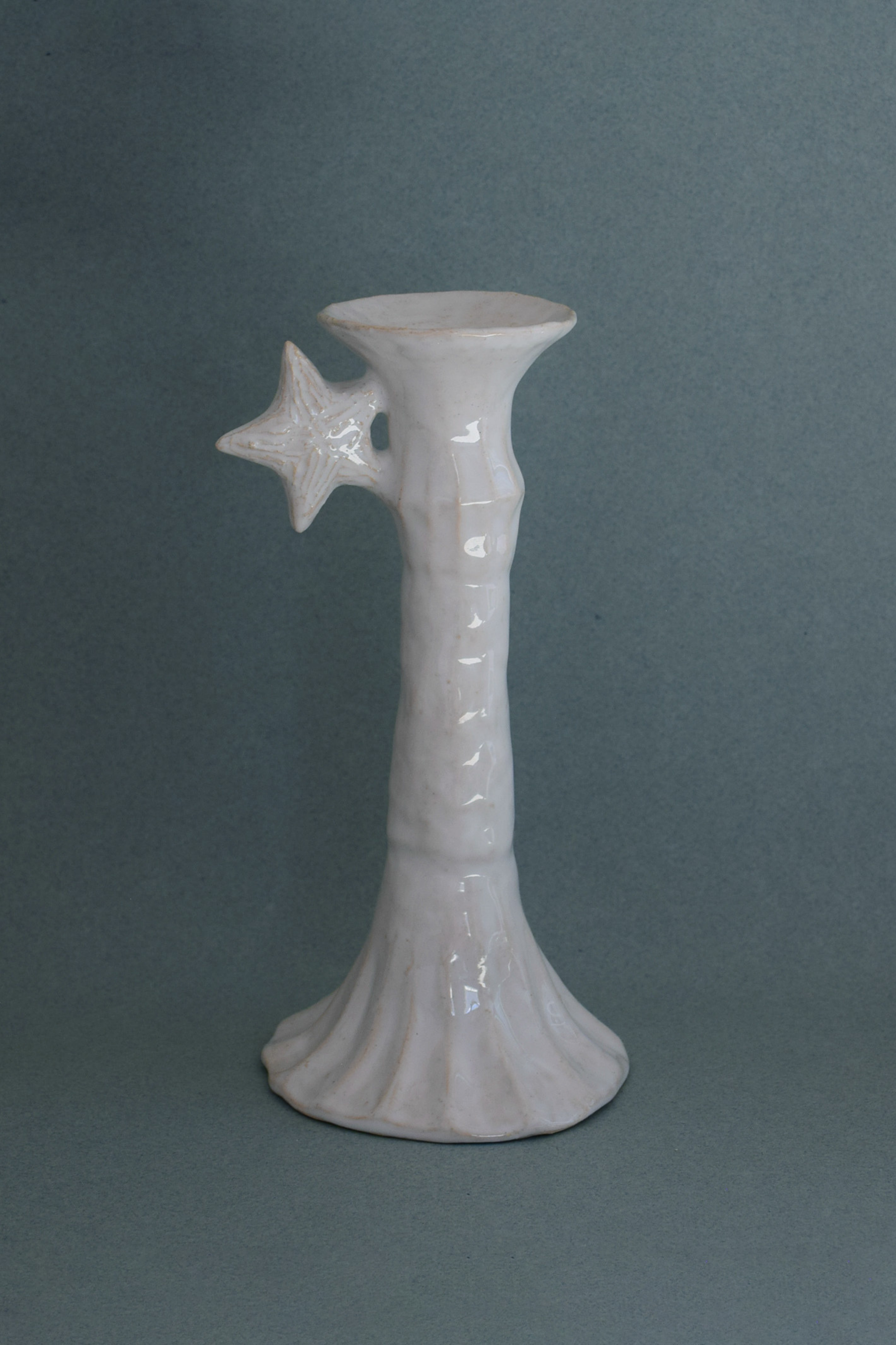 Le Grand Chandelier, issu de la collection Pierrot, évoque l’univers tendre et mélancolique du célèbre clown rêveur. Son modelage, tout en douceur, rend hommage à la nuit et à ses étoiles en s'inspirant de la célèbre comptine Au Clair de la Lune. Qu’il éclaire une table de chevet ou un coin de salon, Le Grand Chandelier incarne une poésie discrète. Façonné entièrement à la main, chaque bougeoir présente des irrégularités subtiles qui témoignent d'un geste instinctif.

Pièce unique, fabriquée à la main