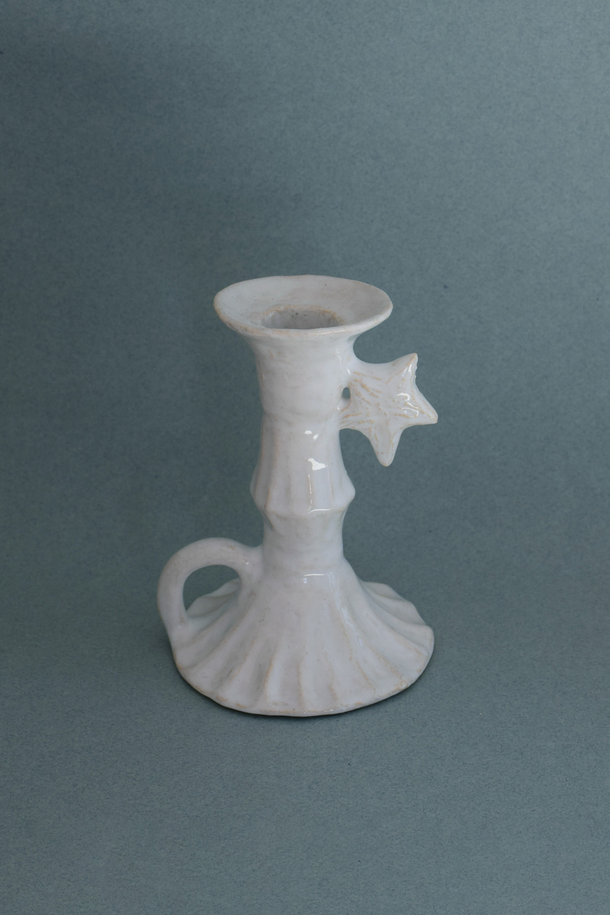 Le Petit Chandelier, issu de la collection Pierrot, évoque l’univers tendre et mélancolique du célèbre clown rêveur. Son modelage, tout en douceur, rend hommage à la nuit et à ses étoiles en s'inspirant de la célèbre comptine Au Clair de la Lune. Qu’il éclaire une table de chevet ou un coin de salon, Le Petit Chandelier incarne une poésie discrète. Façonné entièrement à la main, chaque bougeoir présente des irrégularités subtiles qui témoignent d'un geste instinctif.


Pièce unique, fabriquée à la main en r