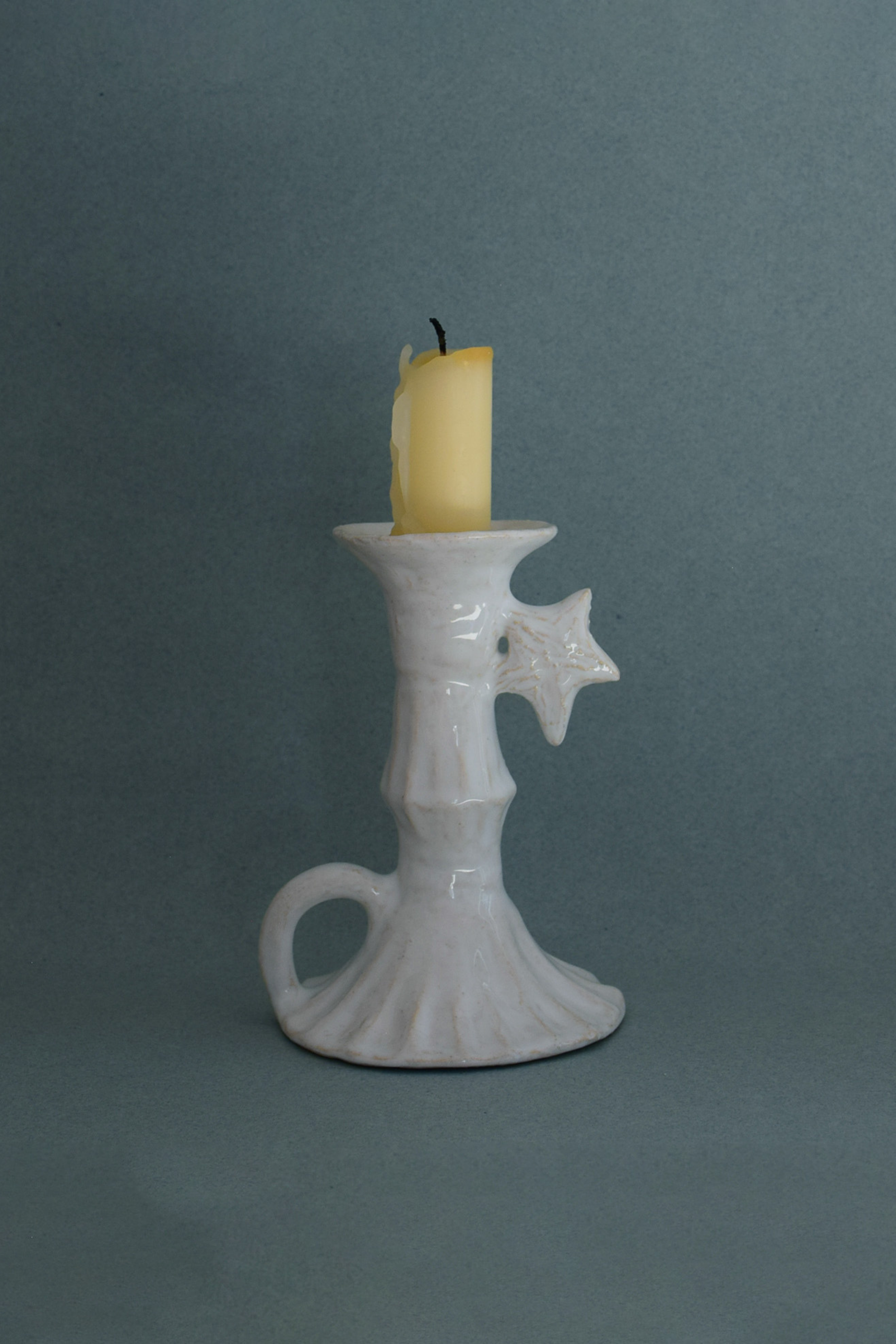 Le Petit Chandelier, issu de la collection Pierrot, évoque l’univers tendre et mélancolique du célèbre clown rêveur. Son modelage, tout en douceur, rend hommage à la nuit et à ses étoiles en s'inspirant de la célèbre comptine Au Clair de la Lune. Qu’il éclaire une table de chevet ou un coin de salon, Le Petit Chandelier incarne une poésie discrète. Façonné entièrement à la main, chaque bougeoir présente des irrégularités subtiles qui témoignent d'un geste instinctif.


Pièce unique, fabriquée à la main en r