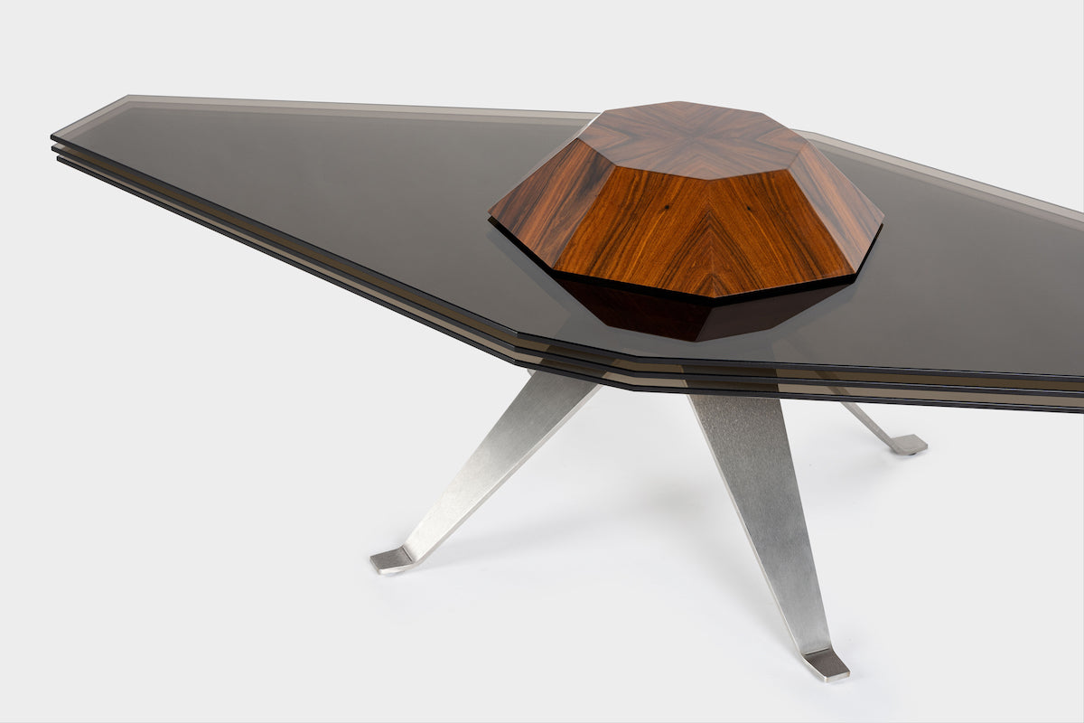 Corps céleste. Atterrissage en douceur pour ce module tabulaire inspiré par Saturne.&nbsp;De forme elliptique ou circulaire, Starsky s’adapte aux envies et habille un intérieur de façon sculpturale. Bien campée sur des pieds en inox massif et son corps en Palissandre Dos Santos, cette table modulable offre de nombreuses options grâce à ses lamelles de verre mobiles&nbsp;qui se déploient tels des panneaux solaires en fonction du nombre de convives.