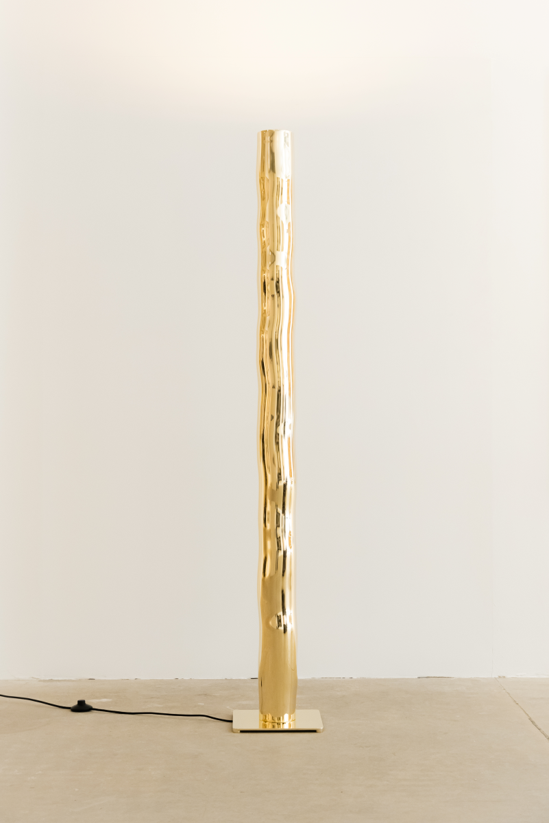 Hélios est un lampadaire sculptural en laiton poli miroir, non verni. Sa source lumineuse, dissimulée, diffuse une lumière douce vers le haut. Entièrement formée, soudée et polie à la main, chaque pièces de cette série sont uniques. Le reflet de sa hauteur dans son socle crée une illusion de mouvement, d’infini, un jeu de perceptions où le vertige s’invite. Hélios transforme l’espace, oscillant entre objet fonctionnel et œuvre sculpturale.