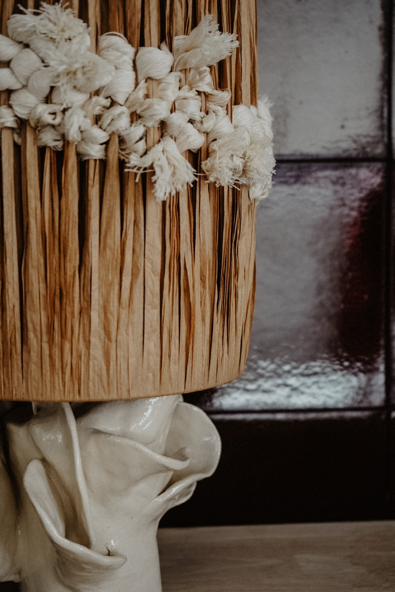 Pour cette lampe, Julie Robert s’est laissé inspirer par les champs de fleurs — surtout des pivoines — qui s’épanouissent chaque printemps sur les hauteurs dominant sa maison du sud de la France. Chaque année, elle observe patiemment la naissance des feuillages, leur croissance silencieuse jusqu’aux dernières récoltes. De cette contemplation rituelle est née l’envie de capturer la grâce éphémère de l’éclosion, de figer dans la lumière les formes mouvantes des pétales.