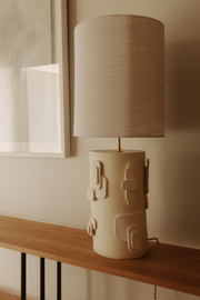 La lampe Cactus en exclusivité chez Caroline Andréoni La Maison, est directement inspirée des esquisses de la créatrice Adeline Delesalle. Cette lampe à poser joue sur des formes en relief évoquant des représentations abstraites de cactus. La profondeur du pied s'associe à un jeu subtil d'ombres et de lumières créé par l'abat-jour, confectionné à base de soie.