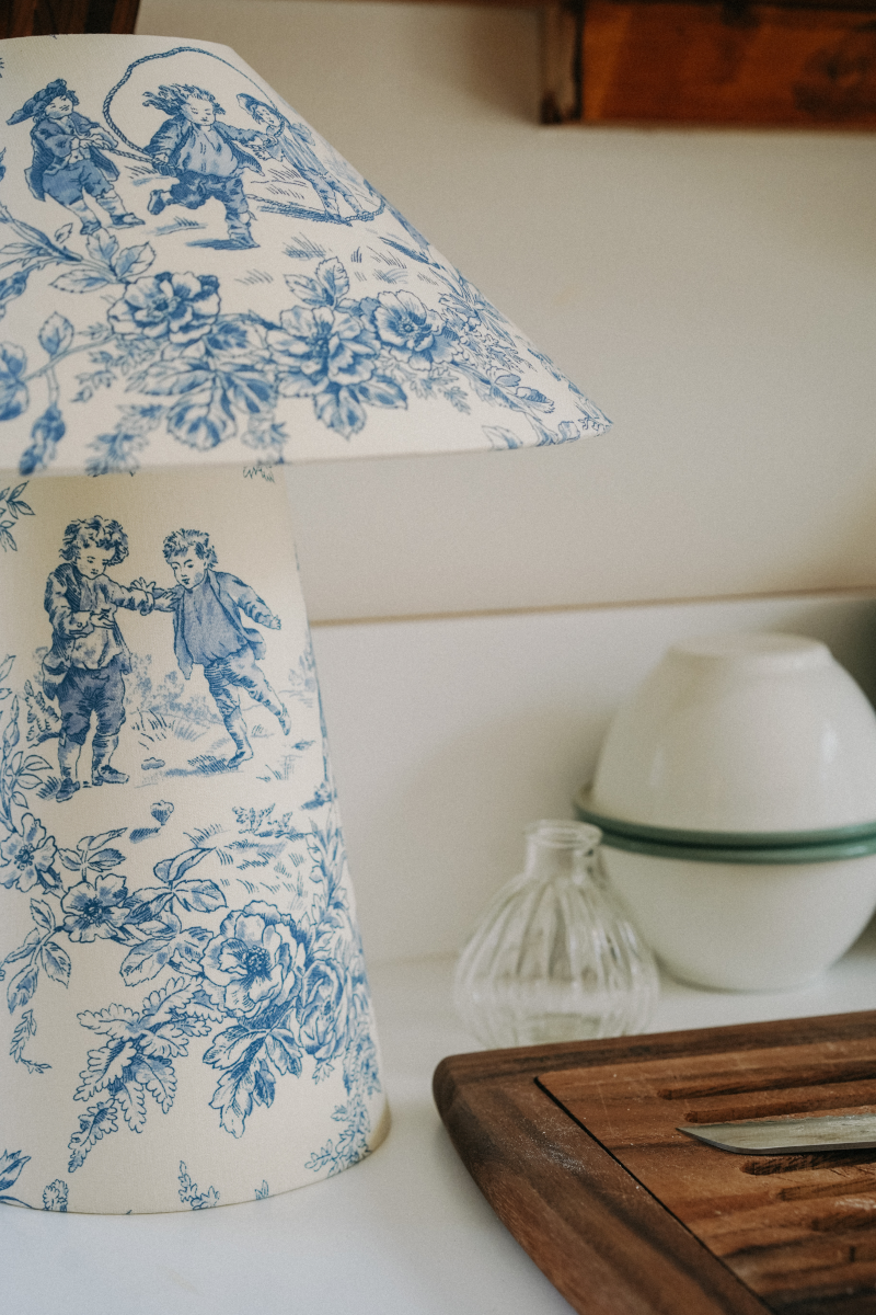 Véritable bijou décoratif, la lampe à poser CARMEN en toile de Jouy bleue et blanche, allie charme intemporel et modernité. La fabrication de chaque lampe est réalisée avec un soin méticuleux par notre abatjouriste dont l’atelier est niché au cœur de la Bretagne en France.

Une fabrication 100% artisanale et française.

Nous célébrons ce processus fait-main, qui est en totale harmonie avec les exigences et les valeurs de notre époque. Chaque modèle de lampe à poser nécessite plusieurs heures de travail