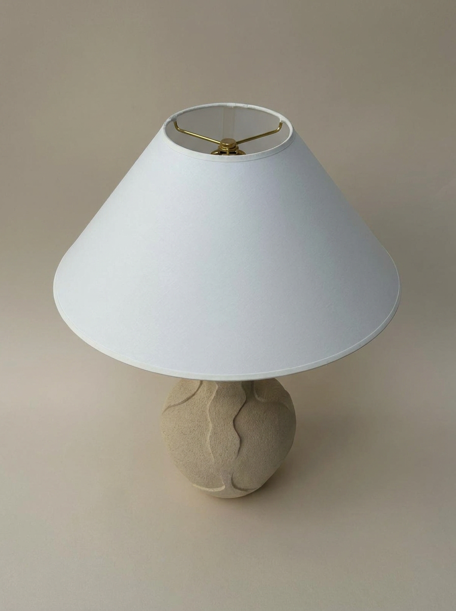 Lampe à poser Paysage, modelée au colombin et à la plaque, en grès crème chamotté brut par Thalia Dalecky : non émaillée, elle semble taillée dans la pierre, habitée de la force calme qui traverse toute la pratique céramique de l'artiste.