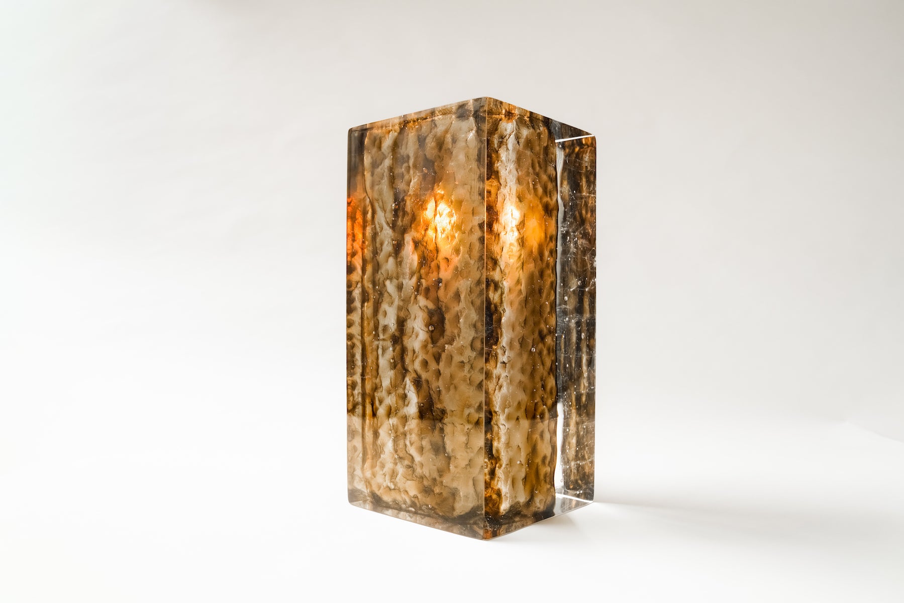 Bougeoir Géoda, réalisé en collaboration avec le verrier Matthieu Gicquel, née d’un dialogue entre matière, lumière et savoir-faire verrier. Inspirée des géodes naturelles, elle explore cette idée de beauté cachée, révélée au cœur de la matière.
À travers un verre travaillé en épaisseur, la collection retranscrit une dualité entre force minérale et délicatesse lumineuse. La matière joue avec la lumière, la capte, la filtre et la diffuse, créant des profondeurs, des reflets et des transparences qui évoluent 