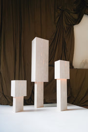 Lampe à poser Lucentia en travertin est née d’une recherche autour de la matière et de la lumière : réussir à faire traverser la lumière à une pierre habituellement perçue comme opaque, pour en révéler une beauté insoupçonnée.
Traversée par la lumière, la matière dévoile alors son paysage intérieur : ses fines aspérités, ses cristallisations, ses microcavités habituellement invisibles. La pierre semble changer de nature, passant d’un matériau dense et minéral à une présence presque vivante et aérienne.