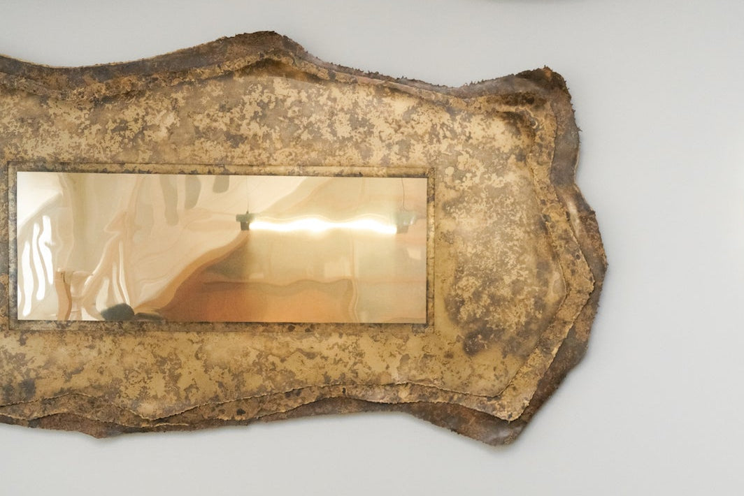 Miroir Chloris en laiton aux patines végétales de Yannick Szekany où le temps et le vivant se lisent dans la texture du métal. Cette pièce est inspirée des feuilles qui jongent le sol en période automnale. Les plantes qui ont servies à son oxydation ont toutes été récoltées dans la forêt de fontainebleau.